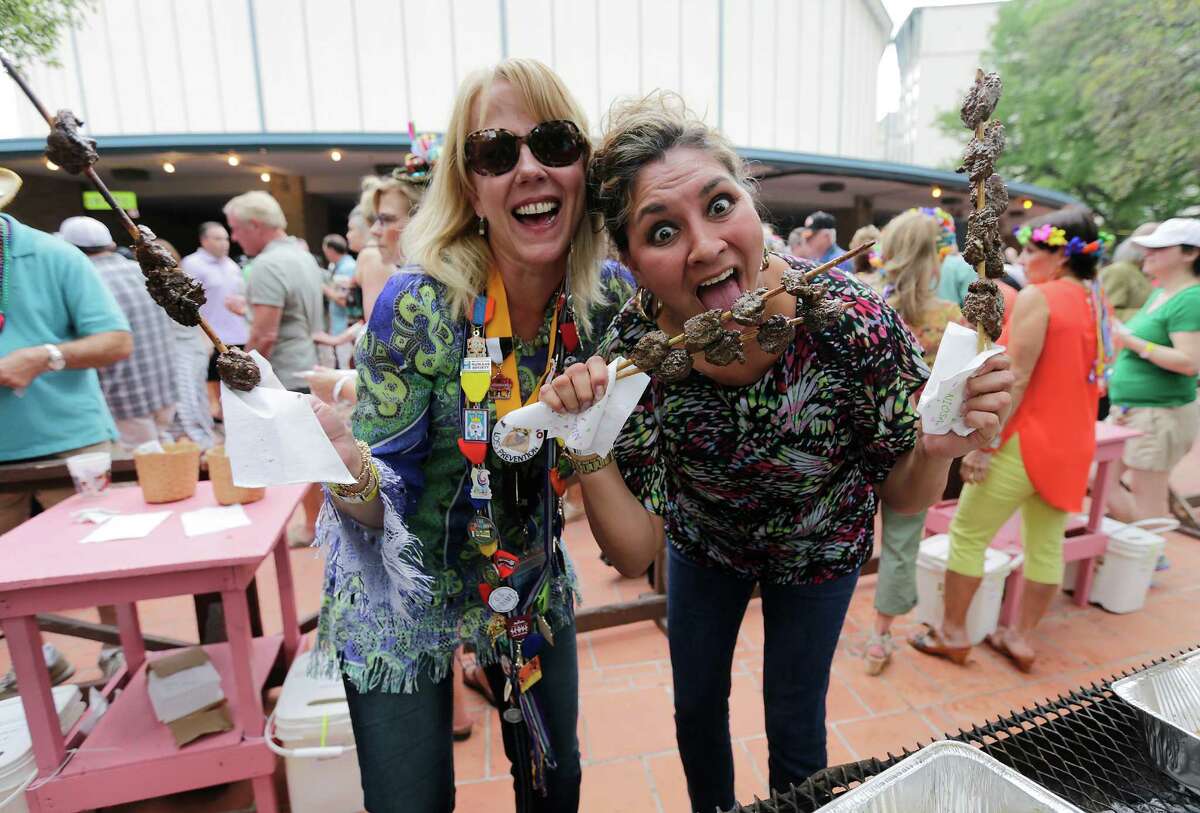 Gaylyn Rockwood (left) and Leticia Gonzalez have some fun serving skewers of cooked beef (anticuchos) at the 2015 Night In Old San Antonio at La Villita on Tuesday, Apr. 21, 2015. 