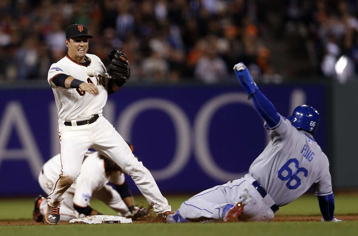 San Francisco Giants' Joe Panik relays to first base after forcing out Los Angeles Dodgers' Yasiel Puig to start inning ending double play in 6th inning during MLB game at AT&T Park in San Francisco, Calif., on Tuesday, April 21, 2015.