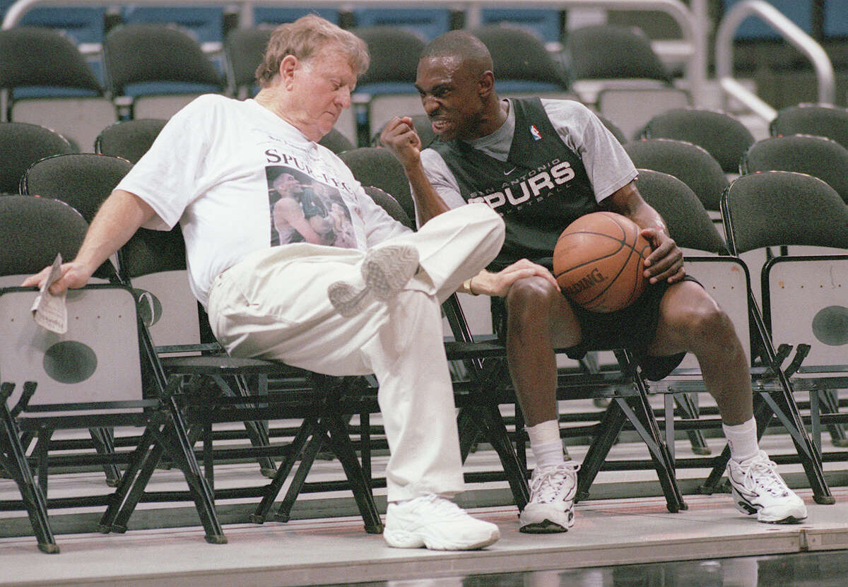 Spurs guard Avery Johnson, right, guestures toward San Antonio businessman and former Spurs owner Red McCombs on June 12, 1999 as they joke around and chat during the team’s practice at the Alamodome.