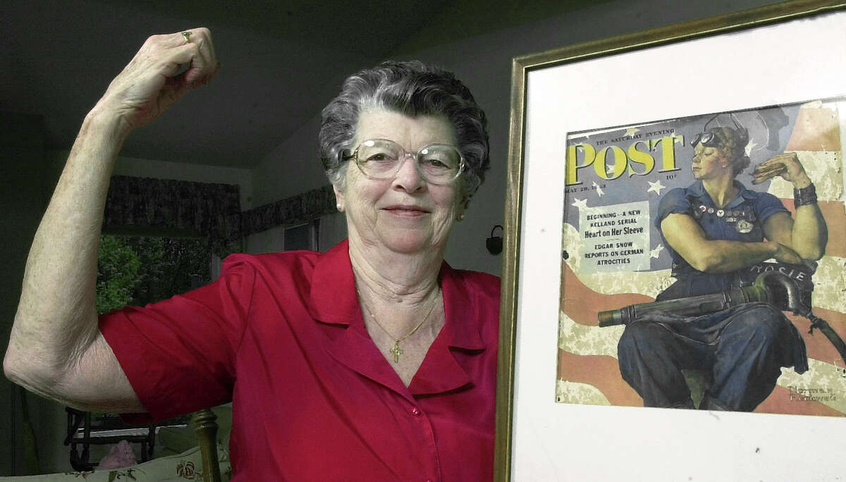 Mary Doyle Keefe poses in 2002 at her home in Nashua, N.H., with the May 29, 1943, Saturday Evening Post cover featuring the Norman Rockwell painting for which she had modeled.
