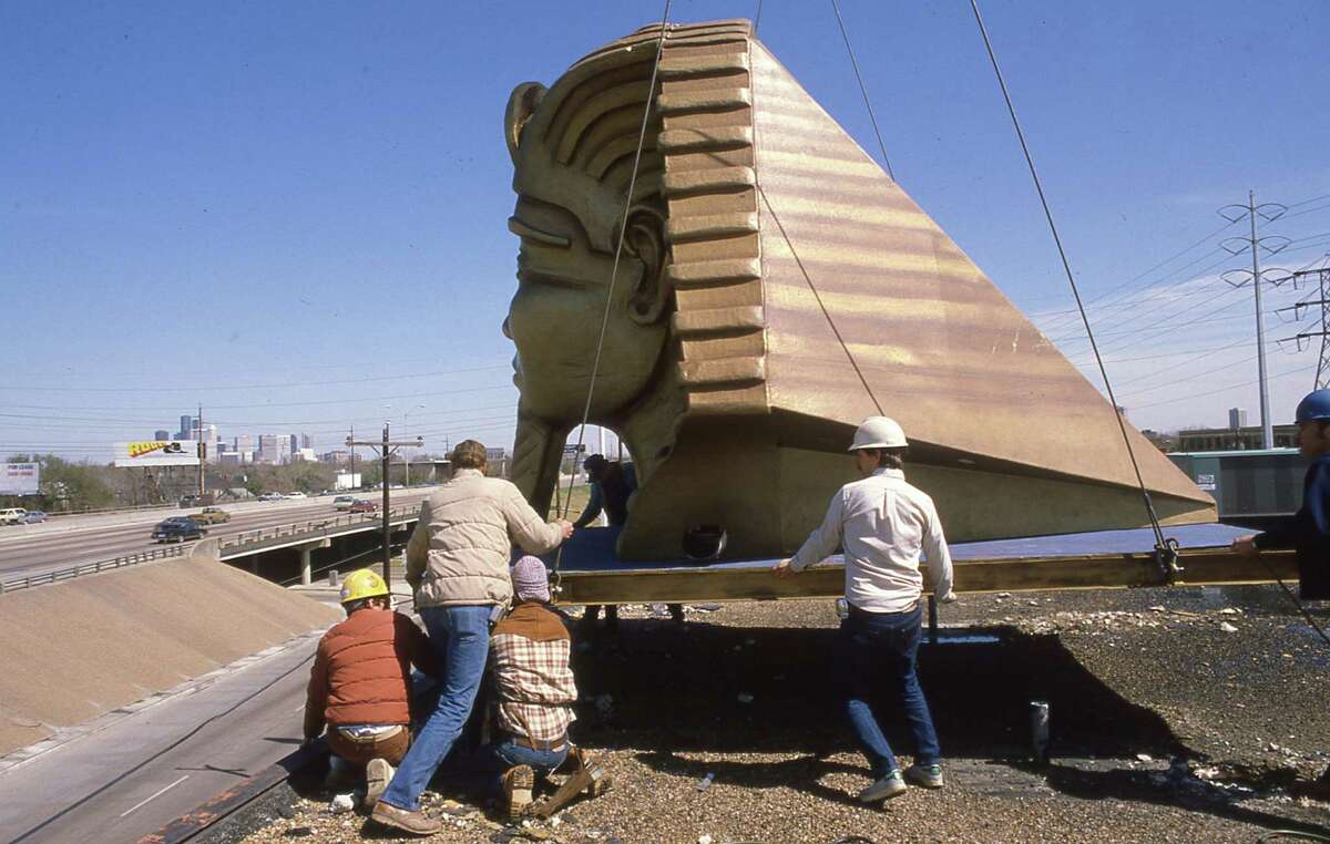 3/6/1984 - Workmen raise a fiberglass Egyptian head tot he top of the Magic Island club at 2215 Southwest Freeway. Owners of the private club say the restaurant will feature magic acts.