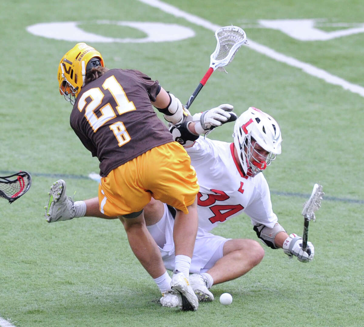 At left, John Fox (#21) of Brunswick takes down Lawrenceville's Charles Burditt (#34) with a check making Burditt lose the ball during the boys high school lacrosse match between Brunswick School and Lawrenceville School at Brunswick in Greenwich, Conn., Wednesday, April 22, 2015. Brunswick won the match, 18-8.