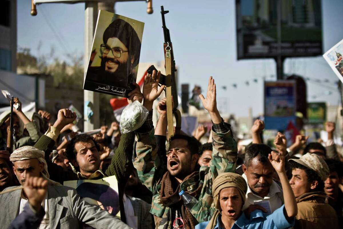 A Shiite rebel known as a Houthi, second left, holds a poster of Hezbollah leader Sheikh Hassan Nasrallah as he attends along with his comrades a protest to denounce the Saudi aggression in Sanaa, Yemen, Wednesday, April 22, 2015. Yemenâs Shiite rebels, who have taken over large parts of the country and have faced a Saudi-led air assault, said Wednesday they welcome United Nations-led talks to find a political solution to the conflict. (AP Photo/Hani Mohammed)
