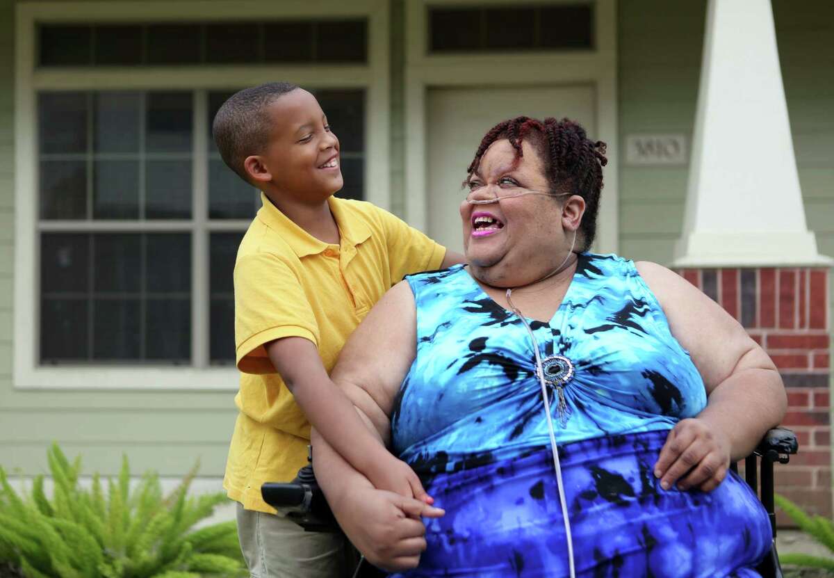 Jordan Melancon, 10, and grandmother Chrystal Jenkins-Washington, 56, share a moment outside her home on Tuesday, April 14, 2015, in Houston. Jenkins-Washington, unhappy with her neighborhood school, Woodson, said she is considering trying to transfer Jordan to a new school. She said his grades have slipped and he gets picked on at Woodson.