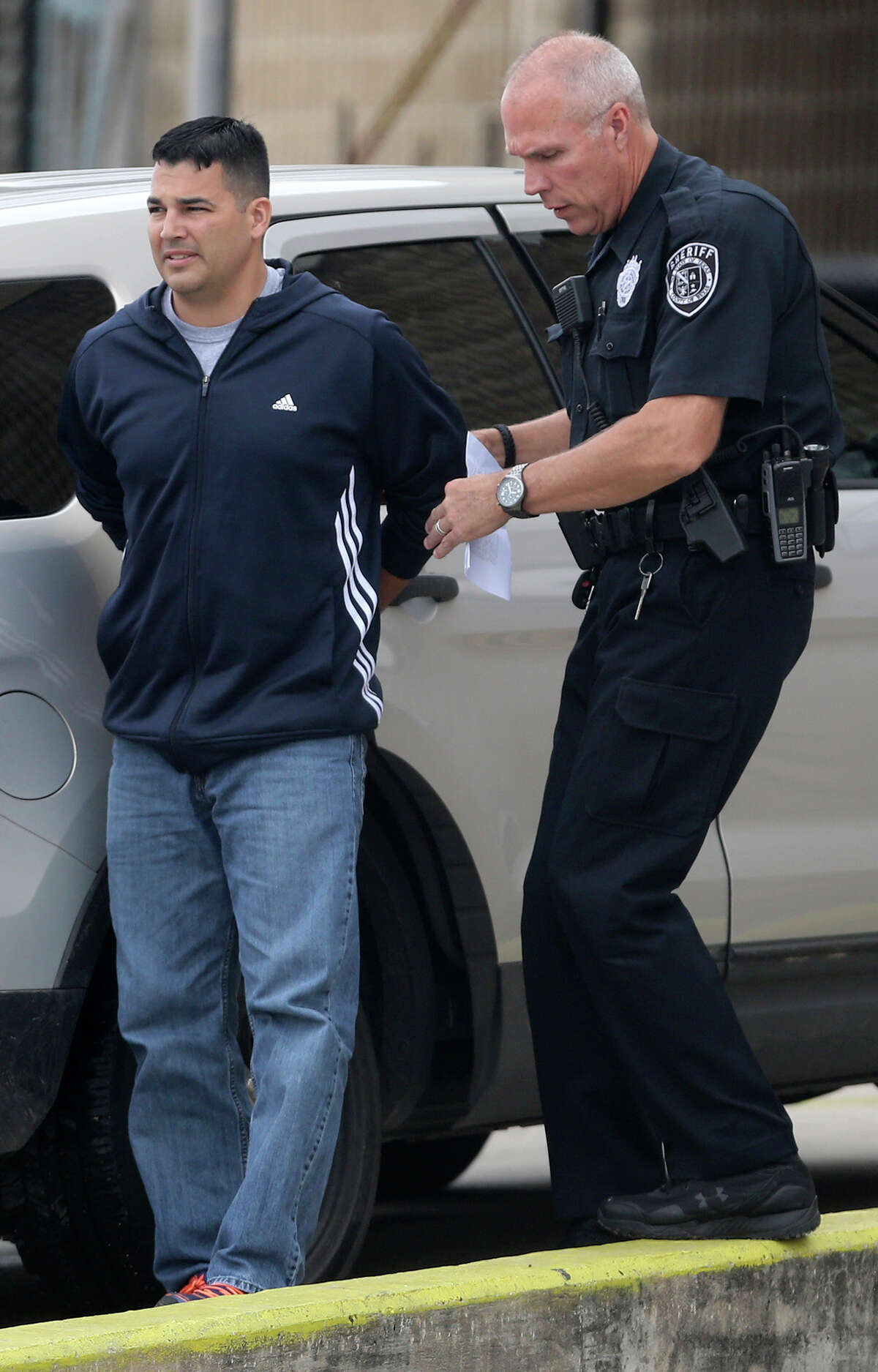 Leonardo Ramos,39, (left) is escorted into the magistrate's office Thursday April 23, 2015. He faces a charge of indecency with a child. Ramos was teaching at the Jubilee Academic Center according to Bexar County Sheriff's spokesman James Keith.