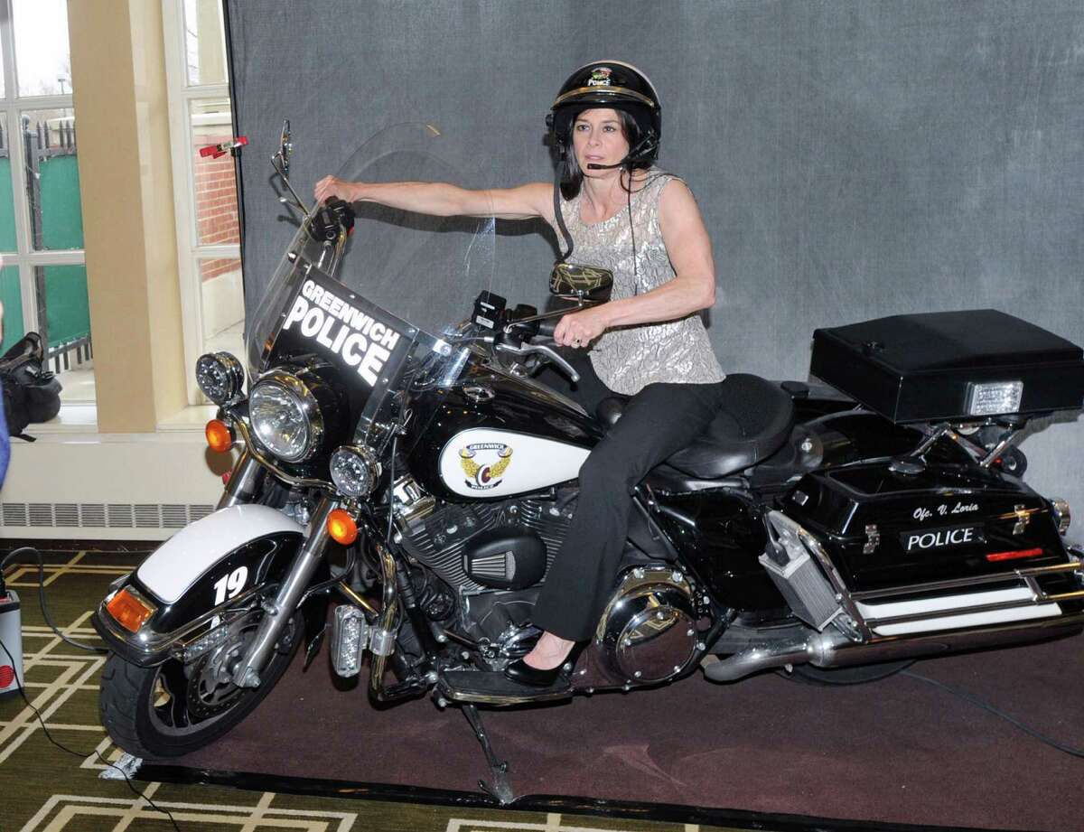 Donna Gioffre of Riverside poses on a Greenwich Police motorcycle during the Greenwich Citizens Police Academy Reunion Dinner at Hyatt Regency Greenwich, Thursday night, April 23, 2015. Gioffre said she is a graduate of the academy. According to the Chairman of the event, John Mastracchio, 160 people attended the dinner to raise funds and awareness for the academy that gives citizens a hands-on education in the complexity of law enforcement in the real world.