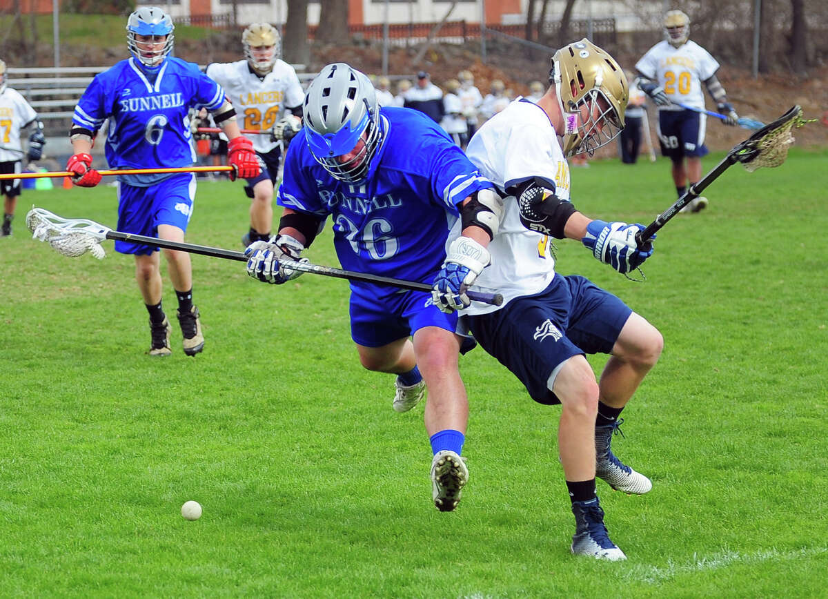 Bunnell's John Minopoli, left, powers past Notre Dame of Fairfield's Brian Boyd to intercept the ball, during boys lacrosse action in Fairfield, Conn., on Thursday Apr. 23, 2015.