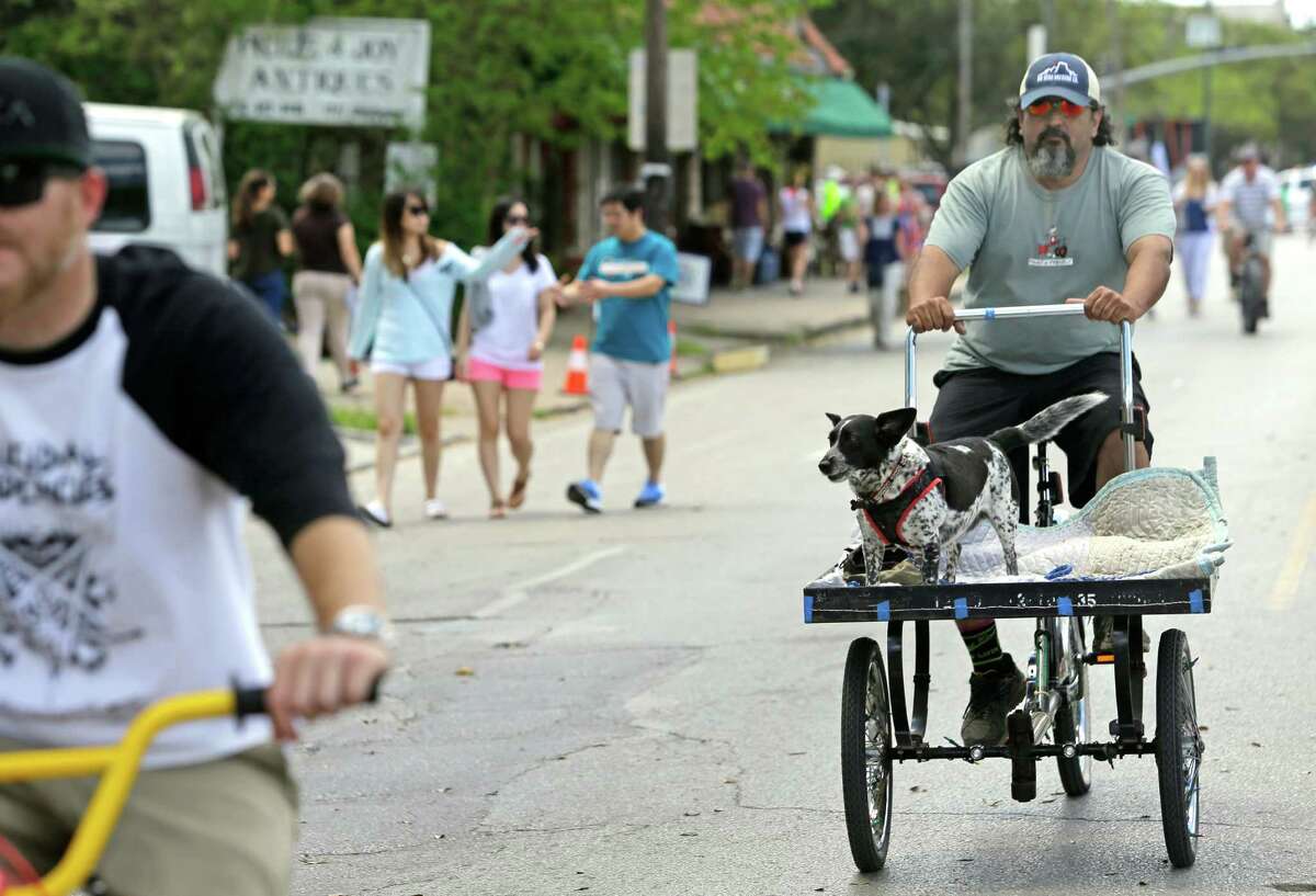 Orlando Perez of Houston gives his dog, Buddy, at ride along Westheimer during the Cigna Sunday Streets Sunday on March 29, 2015.