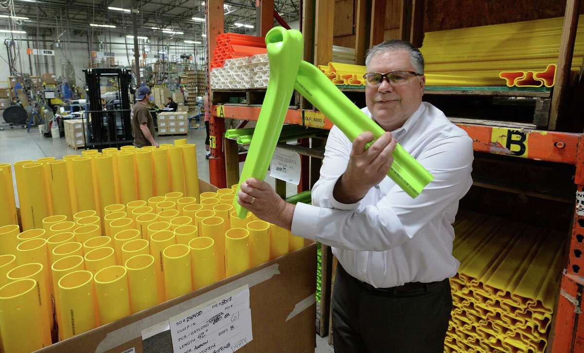 Peter Speer, vice president of sales at Pexco, demonstrates the flexibility and durability of the company's traffic safety poles. The small company ships product in a variety of styles and colors all over the world. Federal insurance from the little known Export-Import Bank covers $2 million of Pexco's sales.