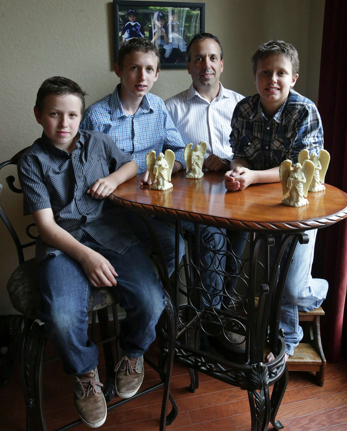 Teddy Voutour relaxes at home with his sons (from left) Skyler, Teddy and Tanner. The family was “hit by a freight train” when the boys’ mother died in 2012, Voutour said.