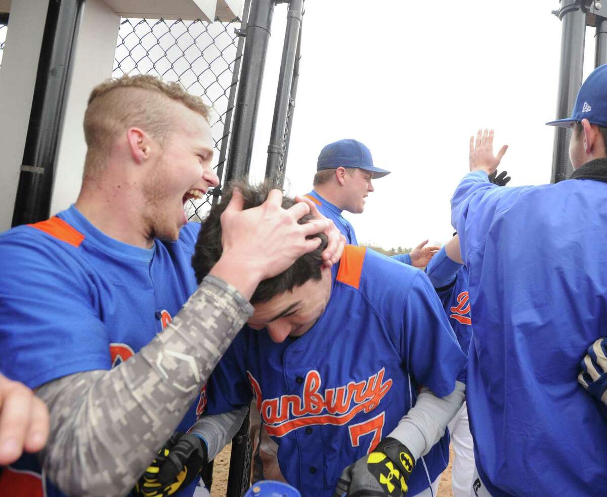 Danbury's Matt Greene, center, is congratulated by teammates including Mike Tucci, left, after Greene hit a 2 run home run in the top of the 4th inning during the high school baseball game between Westhill High School and Danbury High School at Westhill in Stamford, Conn., Friday, April 24, 2015. Danbury won the game, 11-3.