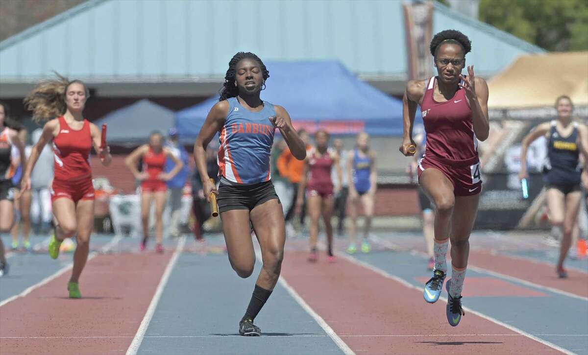Niema Riley, Danbury High School, center, and Jiana Baker, Windsor High School, right, head for the finish line in the girls 4x100 during the high school track and field O'Grady Relays, held at Danbury High School, on Saturday, April 25, 2015, in Danbury, Conn.