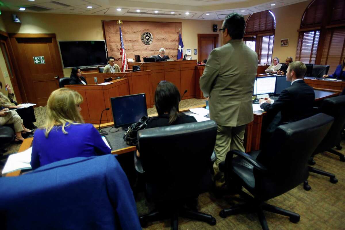 The mother of two children, second from left, listens Wednesday March 11, 2015 to her attorney speak during a hearing in Judge Richard Garcia's courtroom. Judge Peter Sakai is overseeing a "redesign" of Children's Court, which deals with families that have entered CPS system. Begun two months ago, the redesign models off of Family Drug Court, where parents are innundated with services to overcome addiction and to keep or get their kids back, and the approach is far less adversarial than traditional CC. The goal is to safely reunify more kids with familes that have gone through CPS, to empower families instead of punish them and keep more families intact