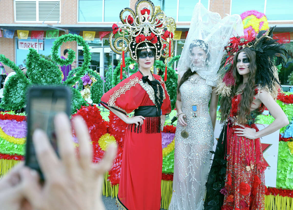 Callisto Griffith (from left), Eugenia Osbon, and Rossi Saenz pose for photos before riding on the Dos Equis float during the Fiesta Flambeau Parade Saturday April 25, 2015.