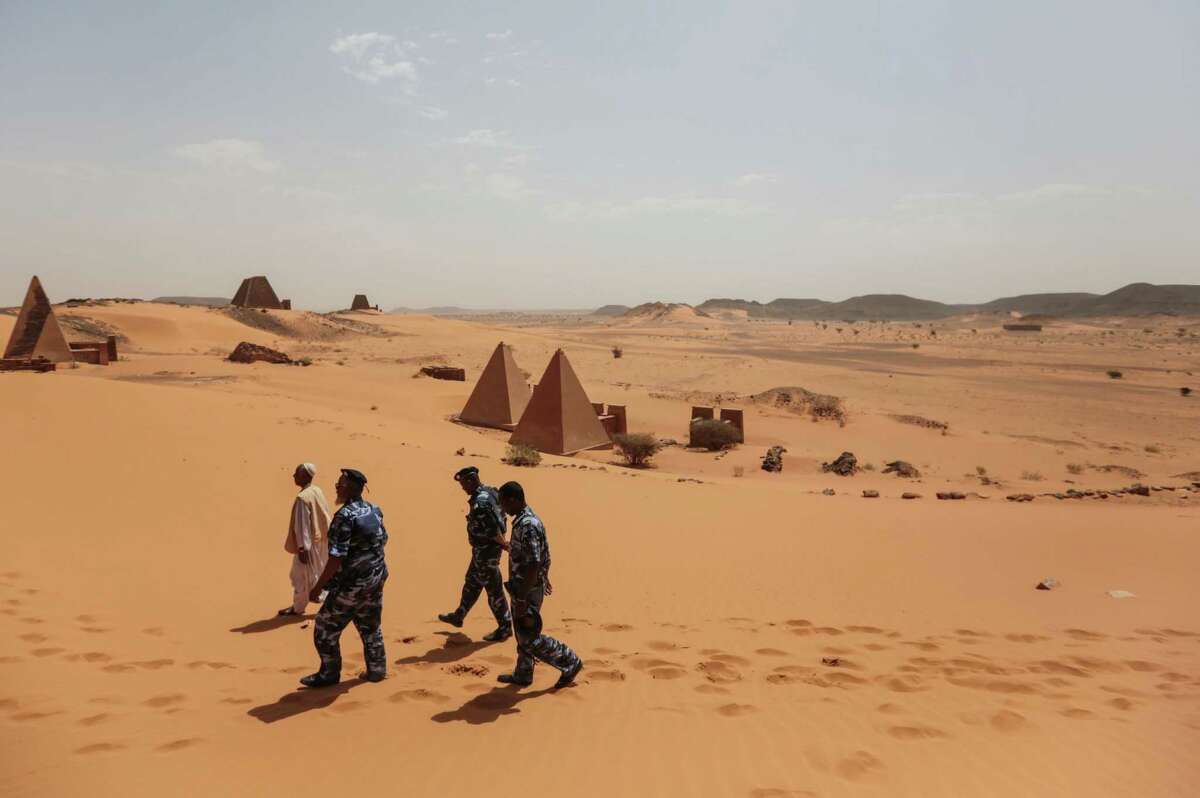 In this Thursday, April 16, 2015, photo, members of the Sudanese security forces guard the historic Meroe pyramids in al-Bagrawiya, 200 kilometers (125 miles) north of Khartoum, Sudan. The pyramids at Meroe are deserted despite being a UNESCO World Heritage site like those at Giza in Egypt.