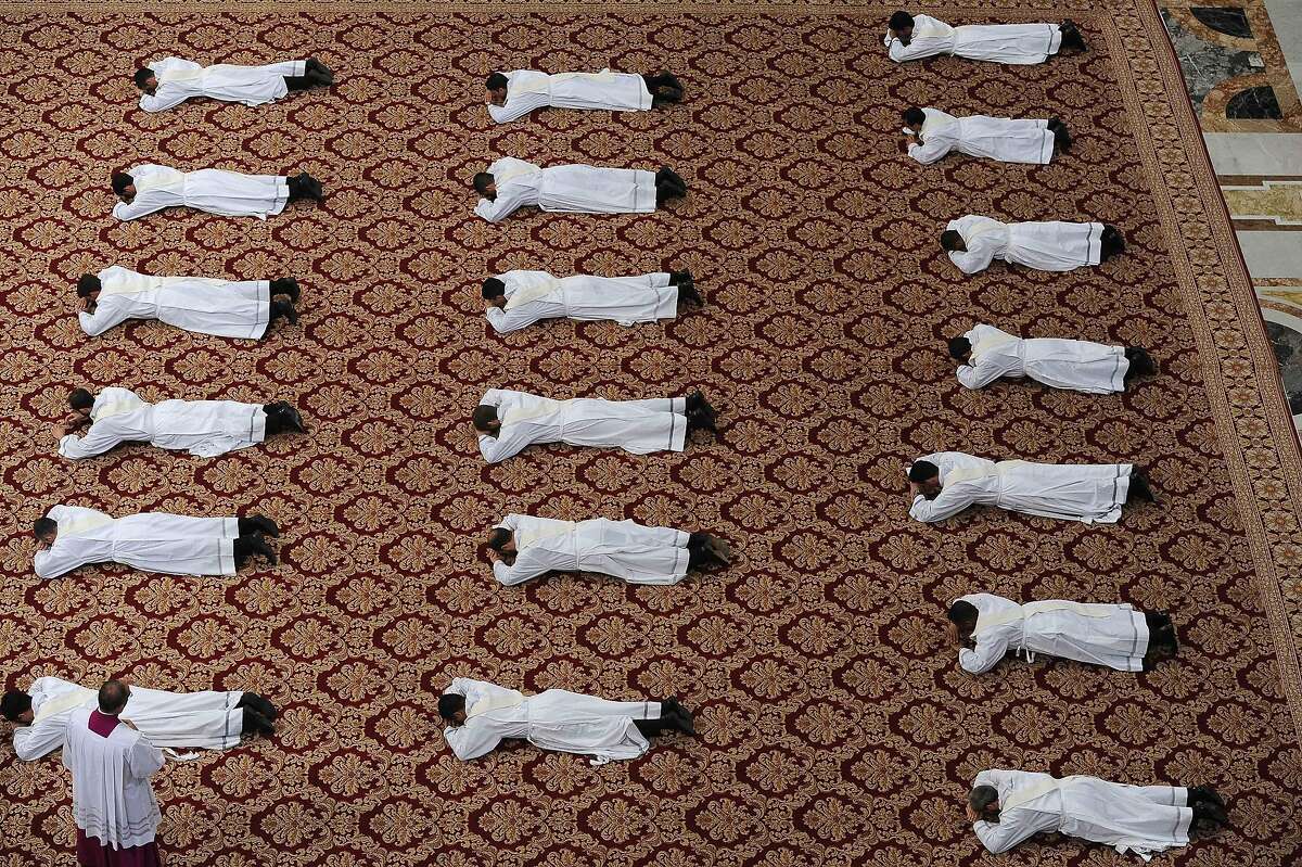 Nineteen new priests lay on the ground during a ceremony in which Pope Francis ordained them, in St. Peter's Basilica at the Vatican, Sunday, April 26, 2015. 