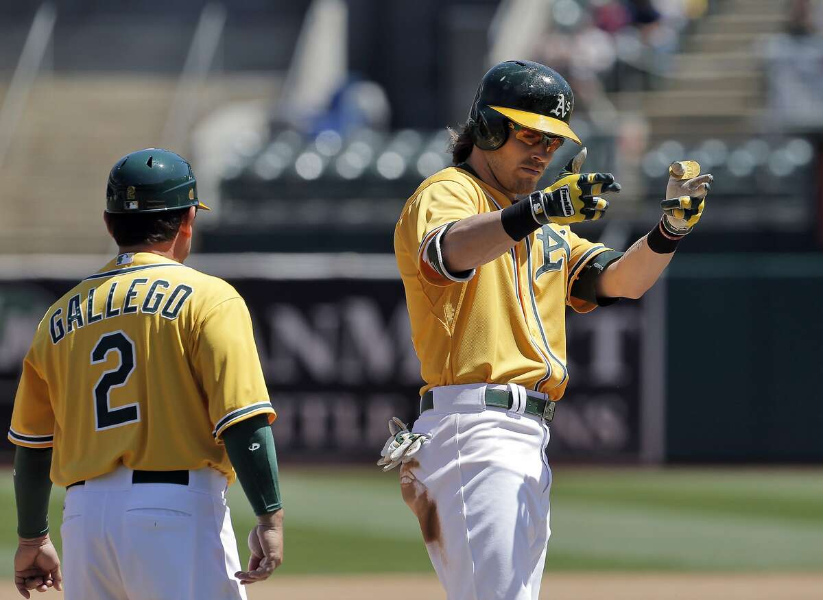 Josh Reddick (22) points to the dugout after hitting a two-rbi triple in the second inning. The Oakland Athletics played the Houston Astros at O.co Coliseum in Oakland, Calif., on Sunday, April 26, 2015. The Astros won 7-6.