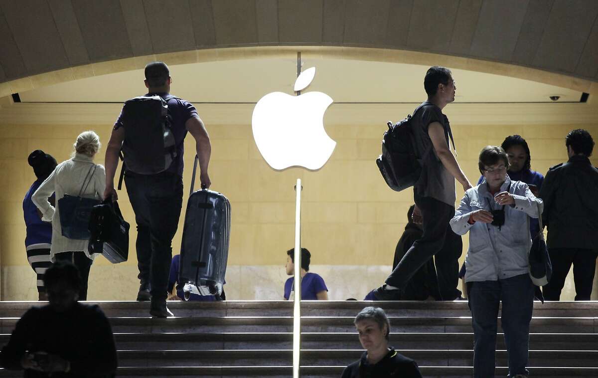 FILE - In this May 11, 2012 file photo, travelers pass the Apple store at New York's Grand Central Terminal. Apple reports quarterly financial results on Monday, April 27, 2015. (AP Photo/Mark Lennihan, File)