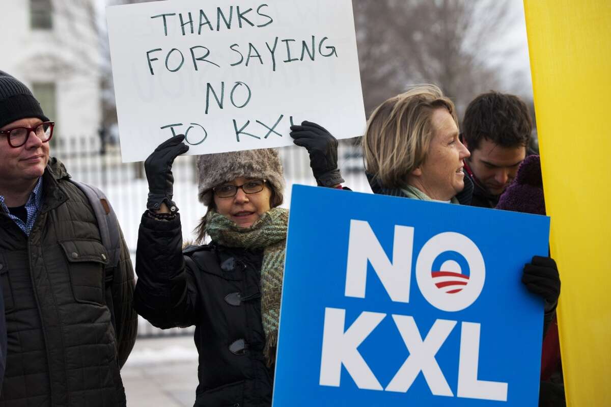 Yvette Torell, left, with 350.org, holds up a sign that says "Thank for Saying No to KXL", next to Melinda Pierce, right, of the Sierra Club, as they join other opponents of Keystone XL to celebrate President Barack Obama's veto of the legislation outside the White House in Washington, Tuesday, Feb. 24, 2015, (AP Photo/Jacquelyn Martin)