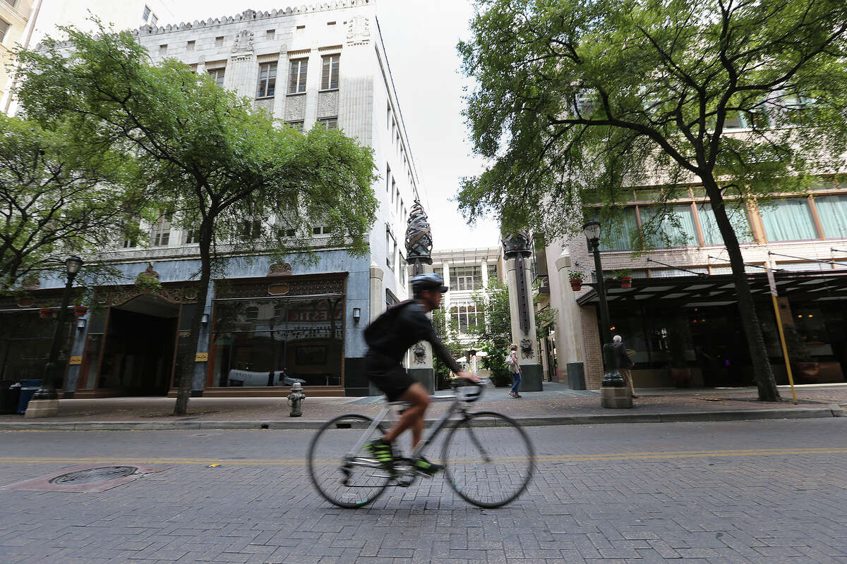 A cyclist rides along East Houston Street by the Bohanan's building. The building, that includes the Cato & Cato offices on the left, is now owned by GrayStreet Partners.