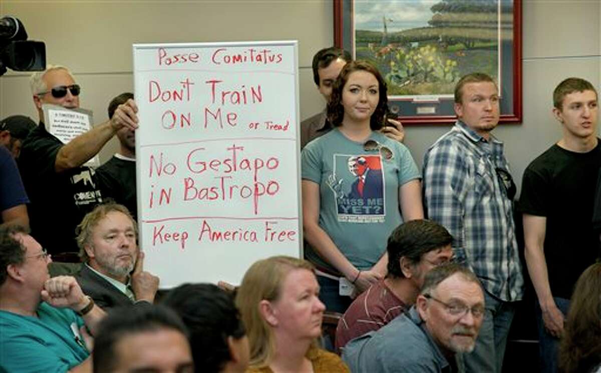 See some of the letters sent to Gov. Greg Abbott's office after his decision to request that the Texas Guard monitor a military training exercise in the state. Bob Welch, standing at left, and Jim Dillon, hold a sign at a public hearing about the Jade Helm 15 military training exercise in Bastrop, Texas, Monday April 27, 2015. (Jay Janner/Austin American-Statesman via AP)