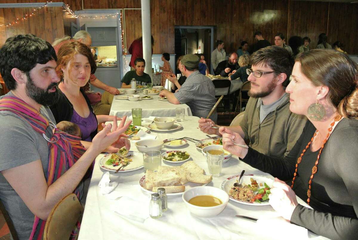 Jason Greco and Katie Nare, of Troy, dine with daughter Freya Nare Greco and converse with Jaron Kuppers and Sarah Parks, also of Troy, at Oakwood Soul Cafe at Oakwood Community Center, April 13, 2015. (Deanna Fox)
