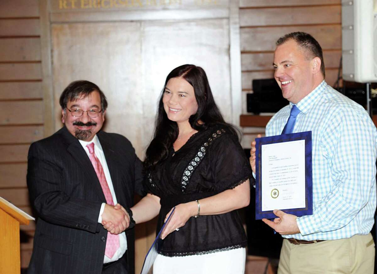 GEMS Deputy Director Art Romano, left, congratulates GEMS emergency medical personnel, Danielle Runyon, center, and Rob Camp, who were both instrumental in saving the life of a head trauma victim who crashed his bicycle while riding in the Montgomery Pinetum in Sept. of 2014, during the Greenwich EMS annual awards ceremony honoring volunteers & staff at the Greenwich Boat & Yacht Club, Greenwich, Conn., Wednesday, April 29, 2015.