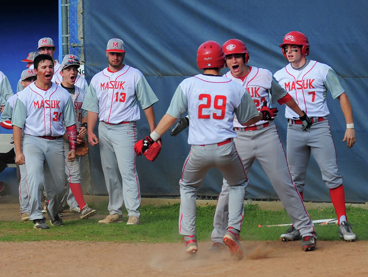 Masuk teammates celebrate as Jay Buhlmann (29) scores, during baseball action against Bunnell in Stratford, Conn. on Friday Apr. 17, 2015.