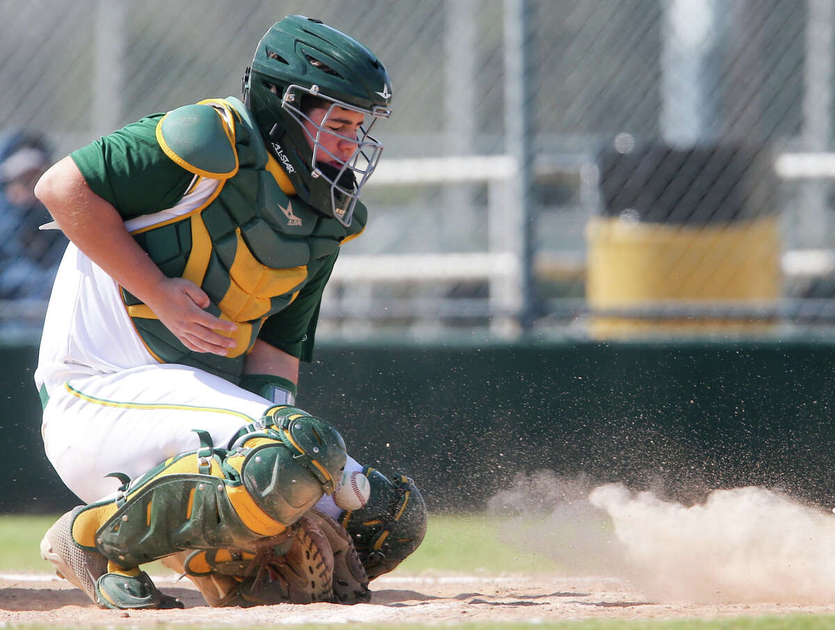 McCollum catcher Justin Zertuche fields a low pitch during their opening game with Medina Valley in the Harlandale tournament at the Tejada Complex on Feb. 26, 2015.