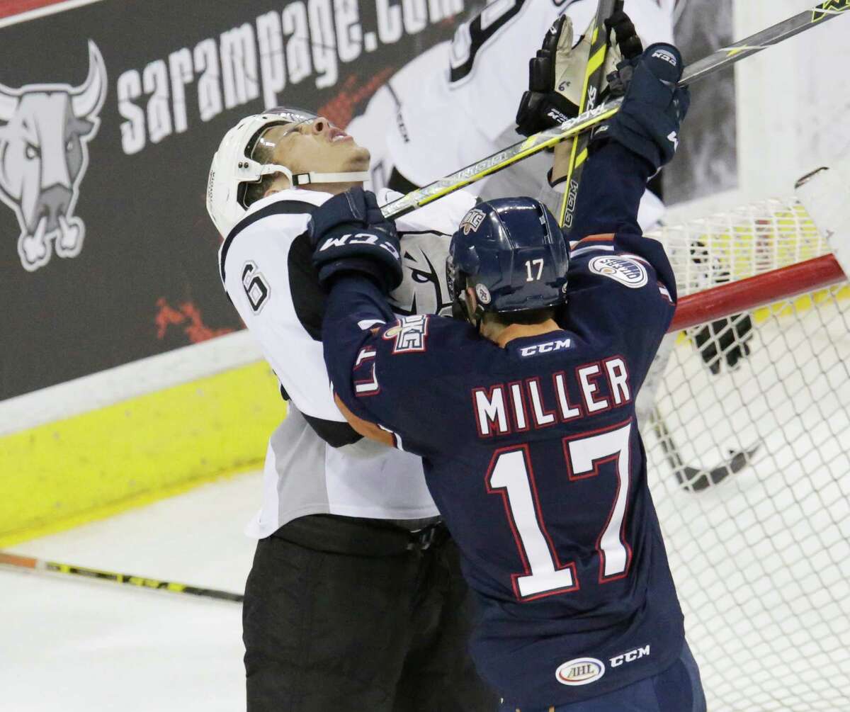 The Rampage’s Jonathan Racine takes a shot to the face from Oklahoma City’s Andrew Miller on Wednesday night at the AT&T Center.