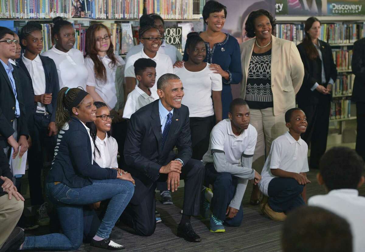 President Obama poses with students after speaking at a live virtual field trip with students from around the country at the Anacostia Library on April 30 in Washington, D.C.