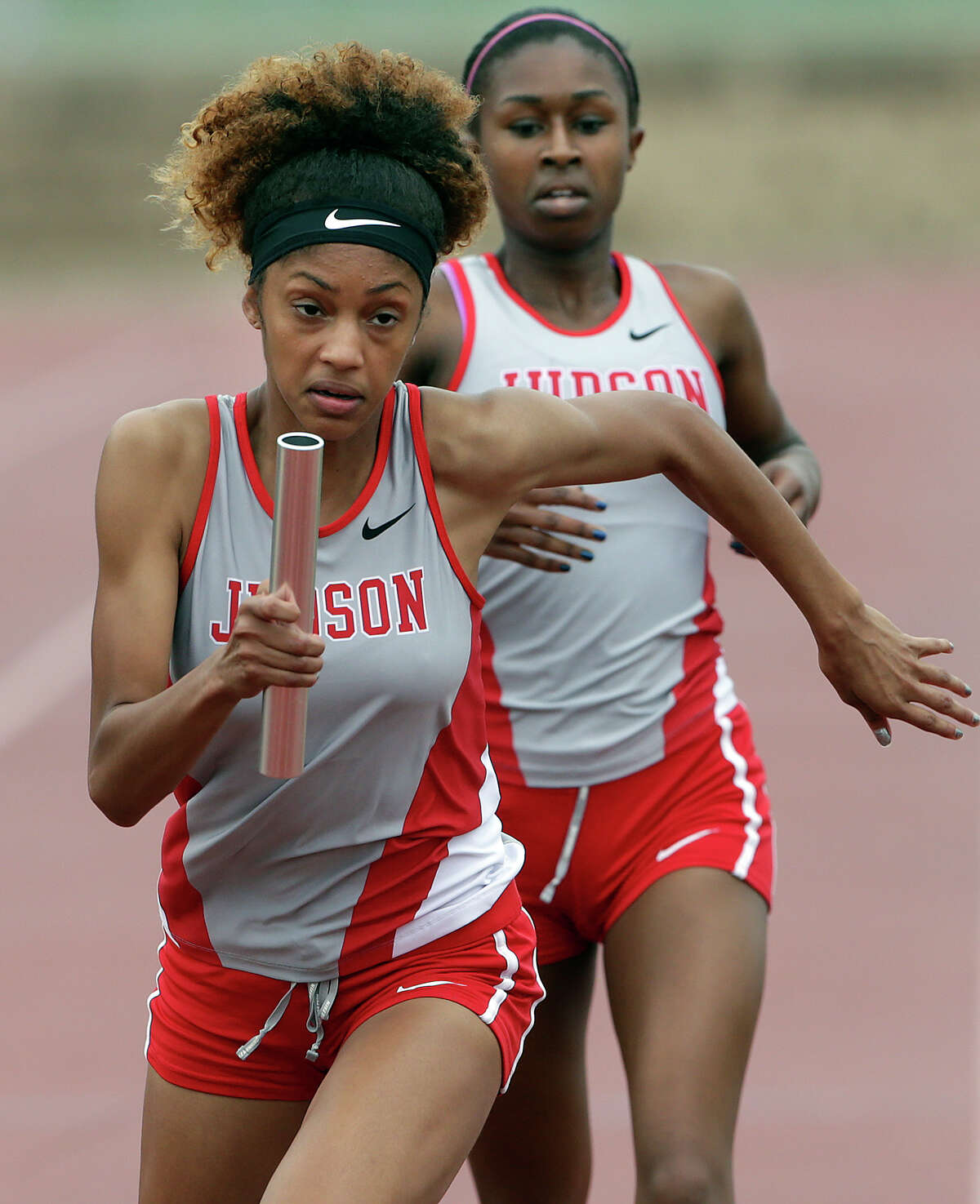 Judson’s Mariah Kuykendoll takes the baton from Zantori Dickerson in the 1,600-meter relay as districts 25/26-6A and 27/28-6A hold area track meets at Gustafson Stadium on April 24, 2015.