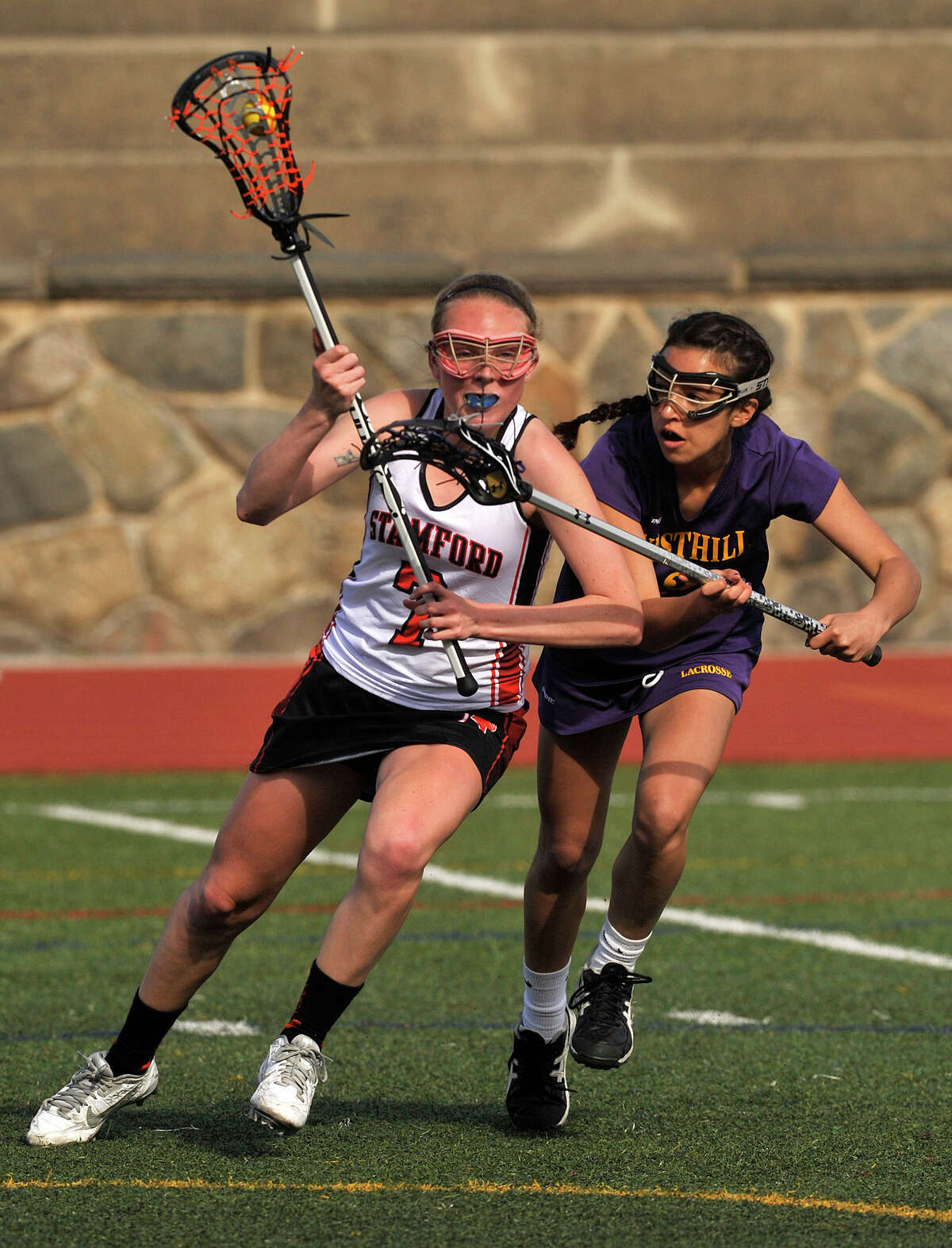 Stamford's Jennifer Krupa fends off Westhill's Alexandra Fischer during their lacrosse game at Stamford High School in Stamford, Conn., on Thursday, April 30, 2015. Stamford won, 14-0.
