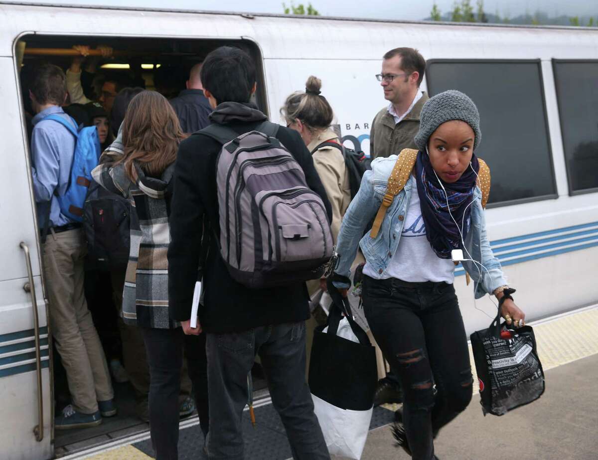 A passenger (right) getting off at the Rockridge BART station has to navigate through a crush of commuters trying to board a San Francisco train in Oakland, Calif. on Tuesday, March 24, 2015. Ridership continues to rise on the regional transit system.