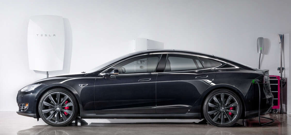 Tesla’s new home-based battery, the Powerwall, shown with the company’s Model S electric sedan.