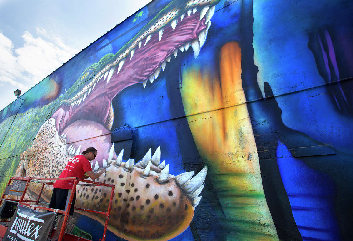 Artist Sebastien "Mr. D" Boileau works on his mural depicting, Ed-U-Gator, the University of Houston-Downtown's mascot, Friday, May 1, 2015, in Houston. The mural will reside on the north side of a storage facility on campus.
