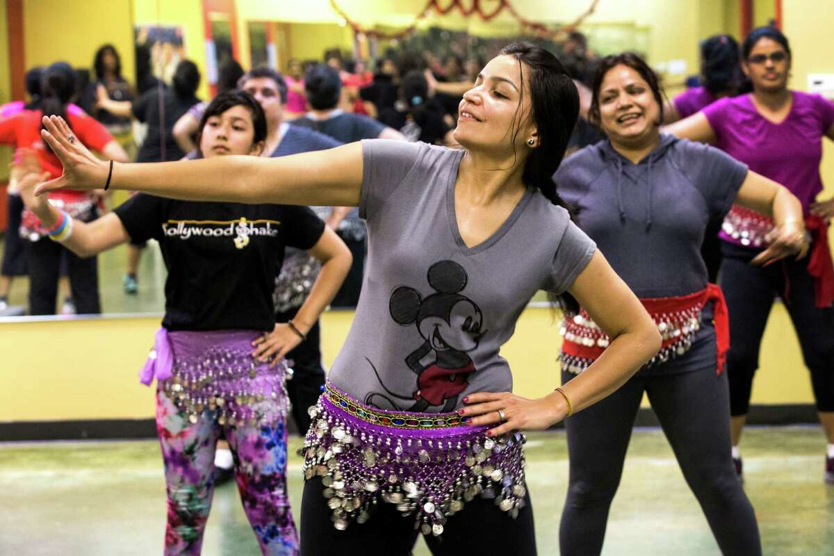 Gayatri Sumant, center, works on perfecting her hand movements during a fitness class at Bollywood Shake. ﻿The class is based on Bollywood music and culture from India with a dash of hip-hop and pop music thrown in to spice things up.﻿
