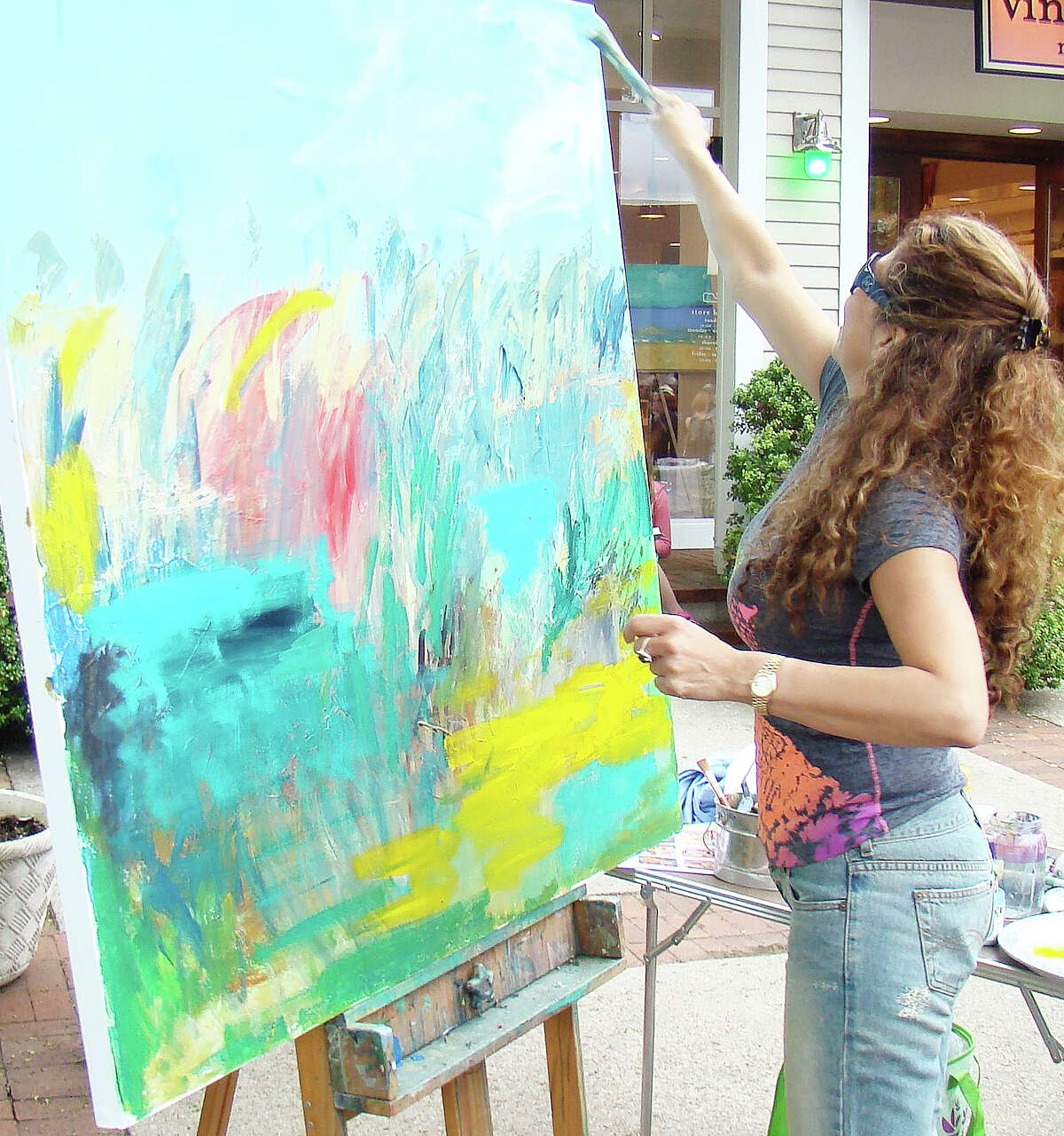 Local artist Sholeh Janati demonstrated her painting technique at a previous Art About Town opening night street party. Artists, musicians, dancers and street performers will line Main Street for the event May 21 from 5:30-8:30 p.m.