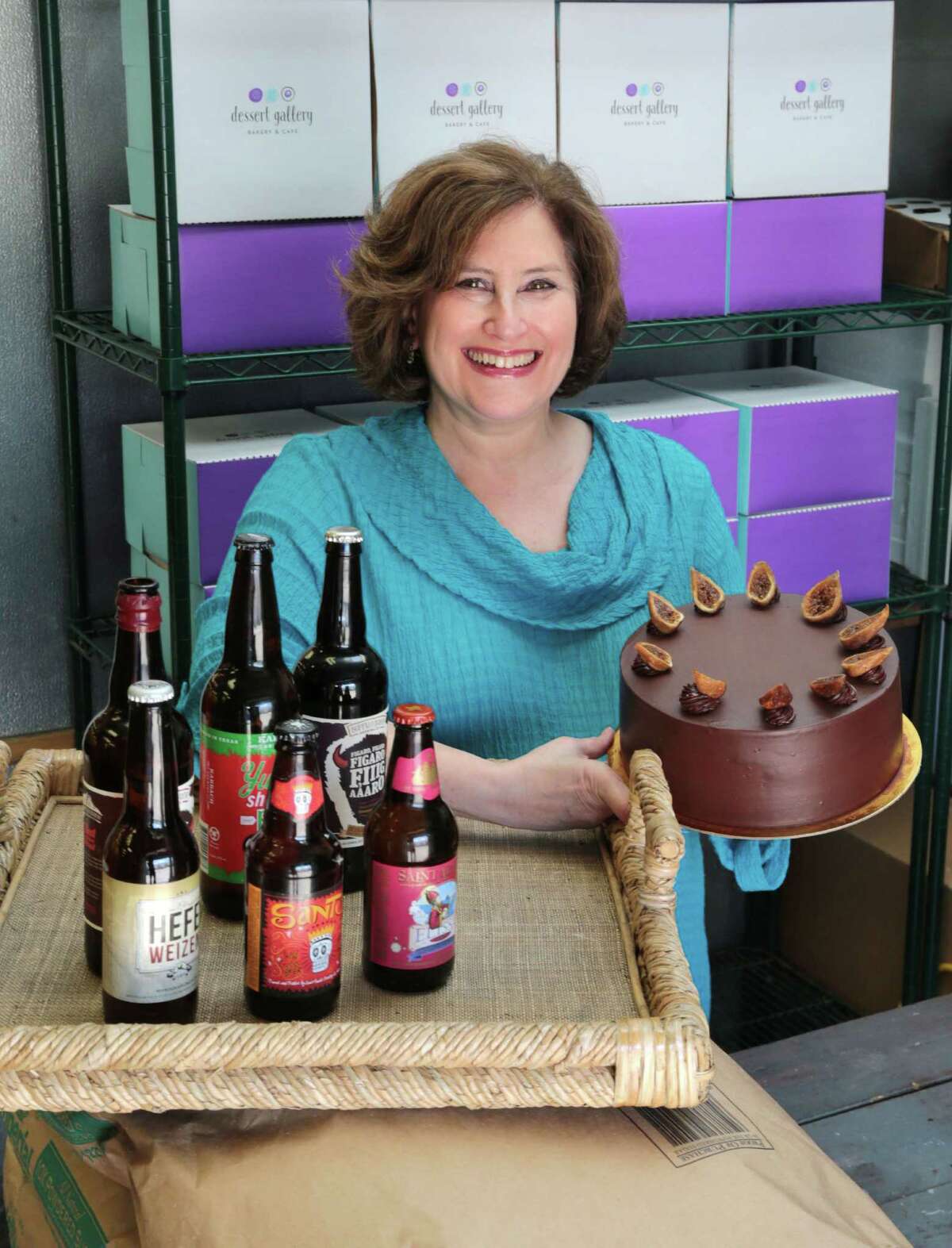 Sara Brook owner of the Dessert Gallery, holds up a Figaro Figaro Fiigaaaro Chocolate Torte made with beer from Buffalo Brewing Co. Wednesday, April 29, 2015 in Houston, Texas. The cake is filled with beer-soaked figs and raisins and topped with dark chocolate ganache The Dessert Gallery, will be featuring locally brewed craft beers in their upcoming Dessert of the Month program. (Billy Smith II / Houston Chronicle)