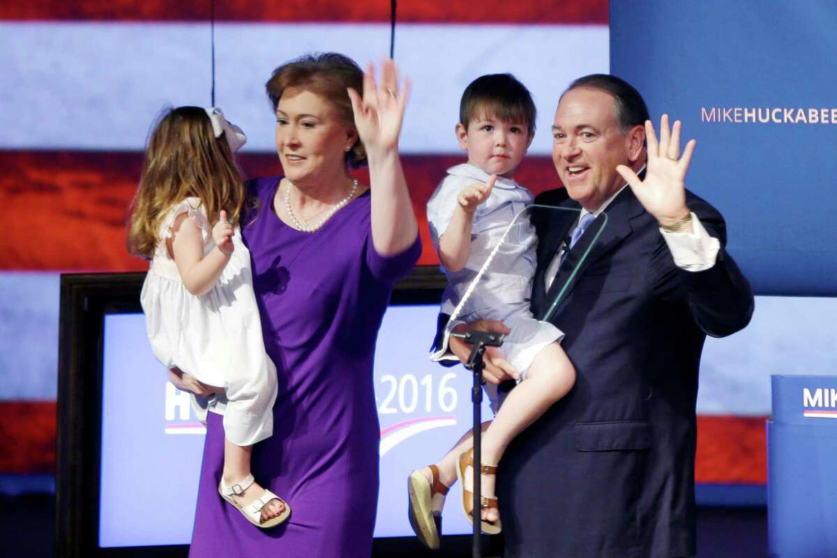 Former Arkansas Gov. Mike Huckabee holds grandson Chandler, as his wife Janet holds granddaughter Scarlett in Hope, Ark., after announcing that he is running for the Republican presidential nomination. ﻿
