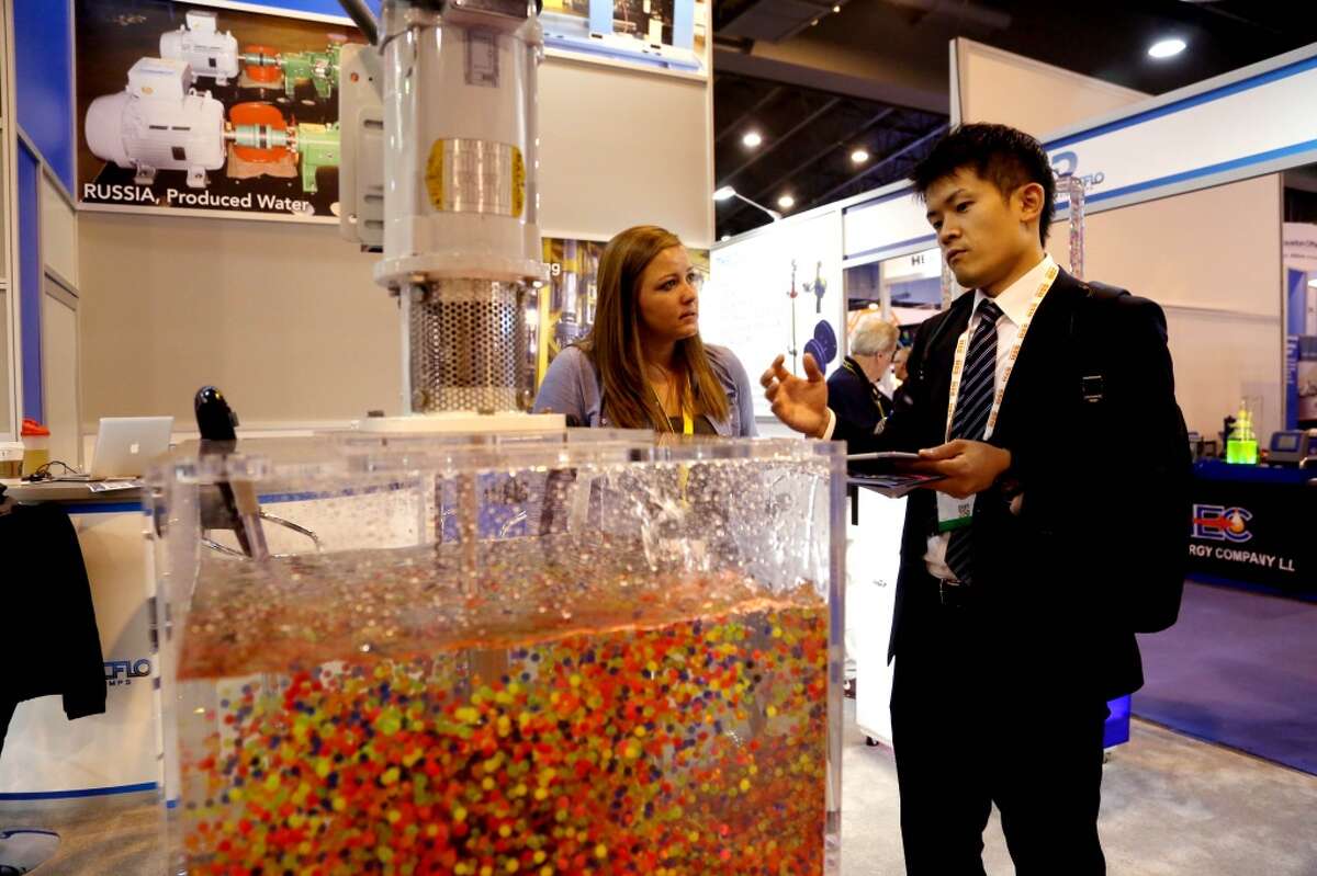 Colored plastic balls are used to show the flow of circulation of a disc pack from a disc mixer at the Discflo Disc Pumps, of California, booth at the Offshore Technology Conference at the NRG Center Tuesday, May 5, 2015, in Houston, Texas. Erica Couch, of Discflo, and Takashi Okada, of Kawasaki Heavy Industries, Japan, are shown in the photo. ( Gary Coronado / Houston Chronicle )