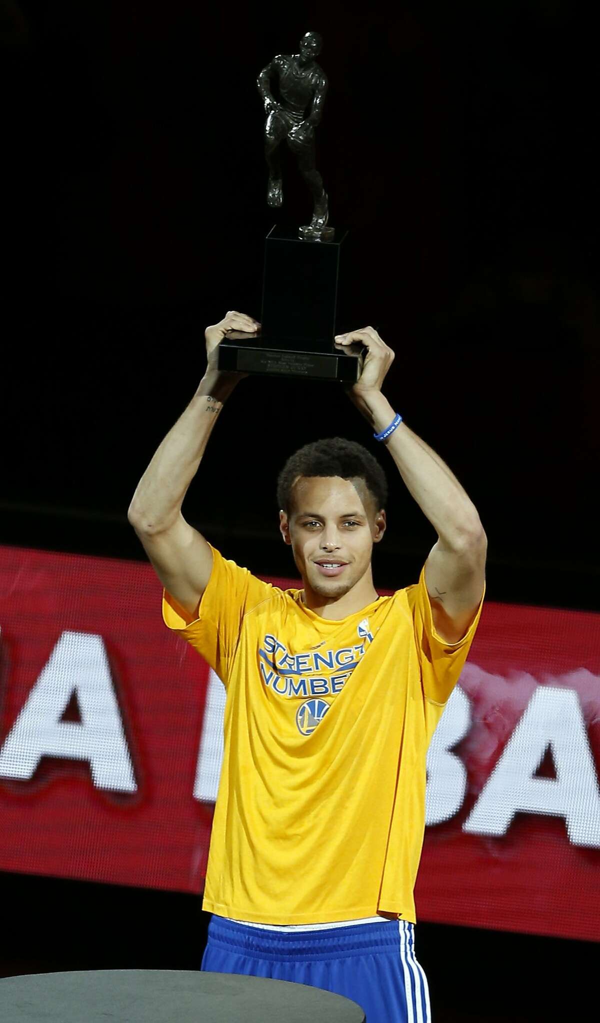Golden State Warriors' Stephen Curry holds up NBA MVP trophy before playing Memphis Grizzlies during Game 2 of NBA Playoffs' Western Conference Semifinals at Oracle Arena in Oakland, Calif., on Tuesday, May 5, 2015.