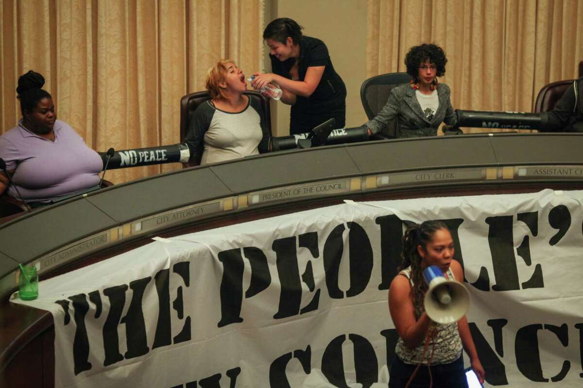 Protesters hold a “People’s Council” after taking over the Oakland City Council chambers Tuesday night.