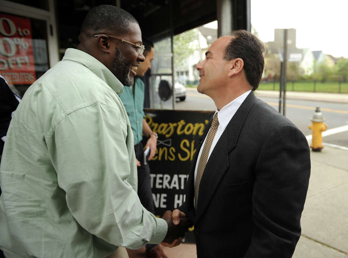 City resident Edward Allen, left, shakes hands with former Bridgeport mayor and newly announced mayoral candidate Joseph Ganim as he courted votes on Stratford Avenue in the city's East End on Wednesday, May 6, 2015.