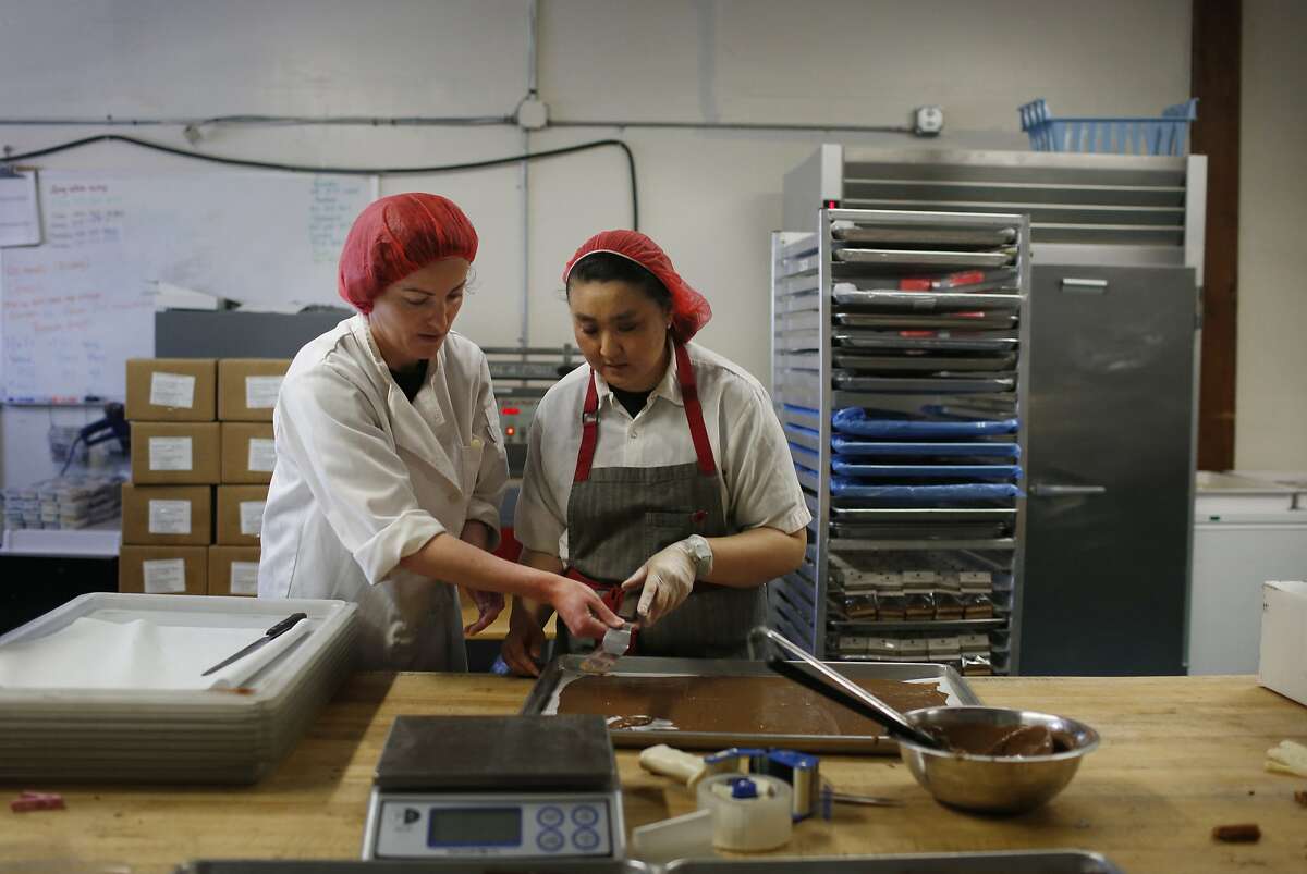 Claire Keane (l to r), owner, trains Marcella Lew for production in the production kitchen at Clairesquares on Tuesday, May 6, 2015 in Sausalito, Calif.