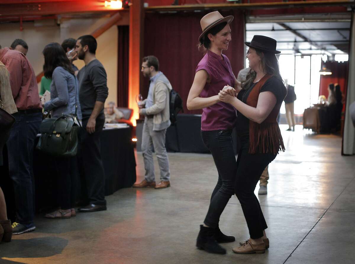 Best friends Gina Astefana, left, and Jessica Furui dance to the Bluegrass music of the Alabama Bow Ties at the "Seven Percent Solution" event at Folsom St. Foundry in San Francisco, Calif., on Wednesday, May 6, 2015. The 7% winemakers poured their wines for a group of drinkers who wanted to try the different, the renegade, the new.The name refers to the fact that 93% of the wine grape acreage in California is given over to only 8 varietals (mostly Cabernet Sauvignon and Chardonnay), while the other 7% is devoted to a myriand of different grapes, a whole range of different types and flavors.