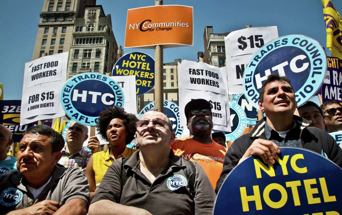 Labor union members and supporters listen during a rally as Gov. Andrew Cuomo announces a plan to get a minimum $15 an hour wage hike for fast-food workers, Thursday, May 7, 2015, in New York. Cuomo is proposing a plan to get a minimum wage hike that doesn't require legislative approval. Cuomo said he will direct the state labor commissioner to examine the minimum wage in the fast-food industry. (AP Photo/Bebeto Matthews) ORG XMIT: NYBM102