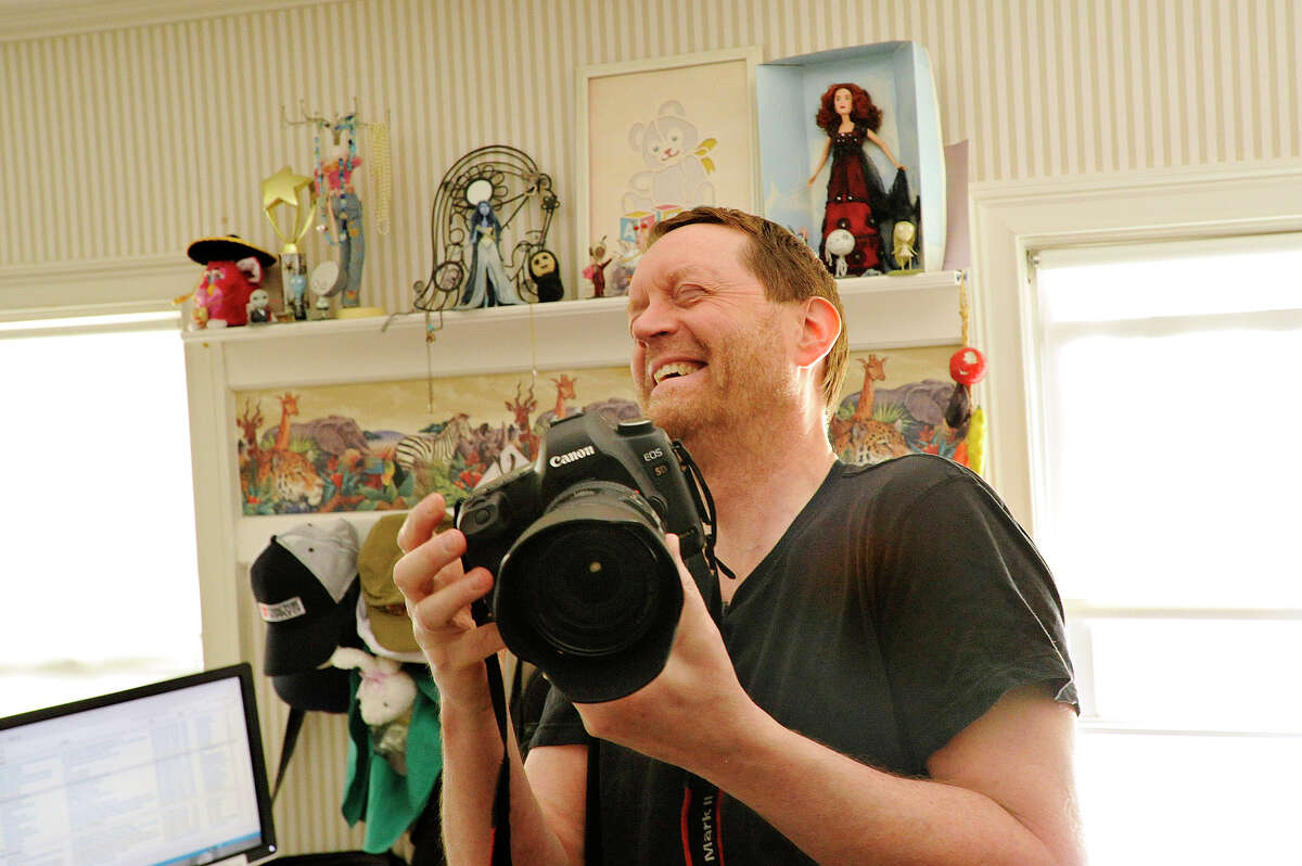 Russ Murray cracks up as he takes a photograph in his home office in Stamford, Conn., on Wednesday, April 29, 2015. Russ says he does "serious haiku and photography."