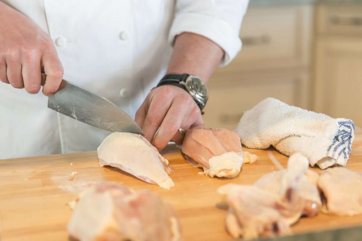 Tyler Florence demonstrates how to cut a whole chicken. Burlingame, California at Riggs Distributing, Inc., Friday March 27, 2015.
