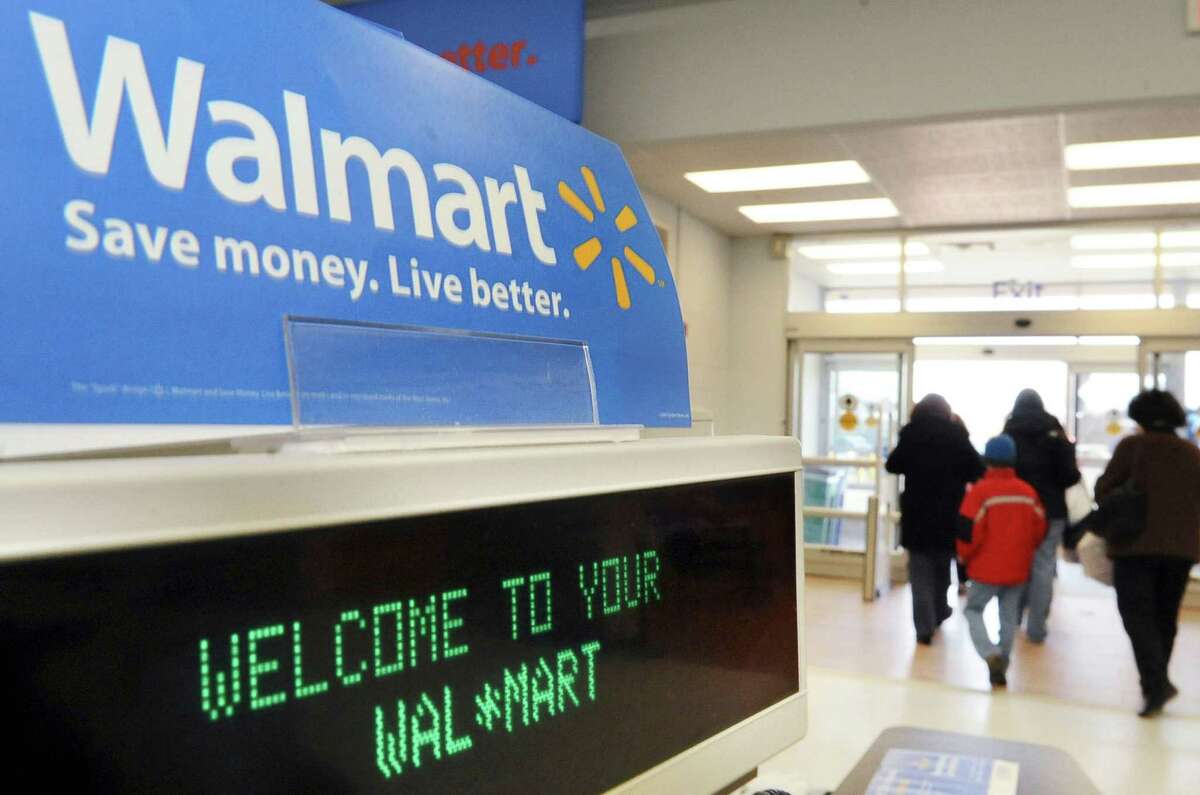 In this Tuesday, Feb. 17, 2009, file photo, shoppers leave a Wal-Mart in Danvers, Mass. Wal-Mart is doing whatever it takes to rope in holiday shoppers however they want to buy. For the first time, Wal-Mart Stores Inc. is offering free shipping on what it considers the season's top 100 hottest gifts, from board games to items related to Disney's hit film "Frozen" items, starting Saturday, Nov. 1, 2014. The move comes as rival Target Corp. began offering free shipping on all items, a program that started late October and will last through Dec. 20. (AP Photo/Lisa Poole) ORG XMIT: NY113